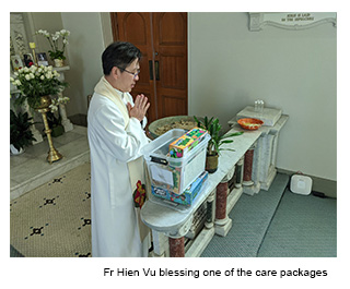 Fr Hien Vu blessing one of the care packages.