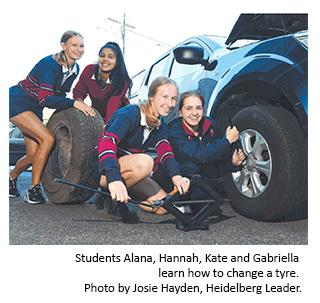 Students Alana, Hannah, Kate and Gabriella learn how to change a tyre.  Photo by Josie Hayden, Heidelberg Leader.